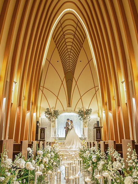 ｜独立型チャペル | チャペル正面 | 自然光が降り注ぐ独立型チャペル。木のアーチが支える誓いの空間 | 独立型チャペル 浜松／自然光 チャペル／フォトジェニック | バージンロード | 白いバージンロードと花の装飾が彩る挙式シーン | 浜松 結婚式場 チャペル／ナイトセレモニー |