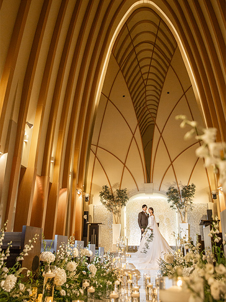 ｜独立型チャペル | チャペル正面 | 自然光が降り注ぐ独立型チャペル。木のアーチが支える誓いの空間 | 独立型チャペル 浜松／自然光 チャペル／フォトジェニック | バージンロード | 白いバージンロードと花の装飾が彩る挙式シーン | 浜松 結婚式場 チャペル／ナイトセレモニー |